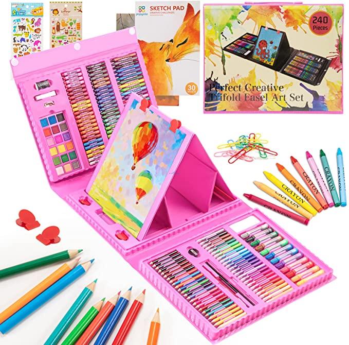 Art kit with oil pastels, watercolor cakes and stickers laid out on wooden table